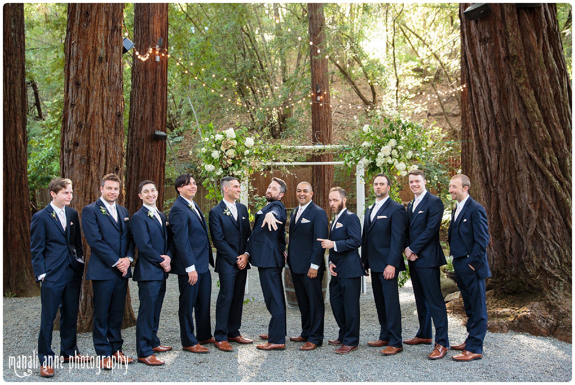 Groom and groomsmen pose beneath the redwoods at Deer Park Villa