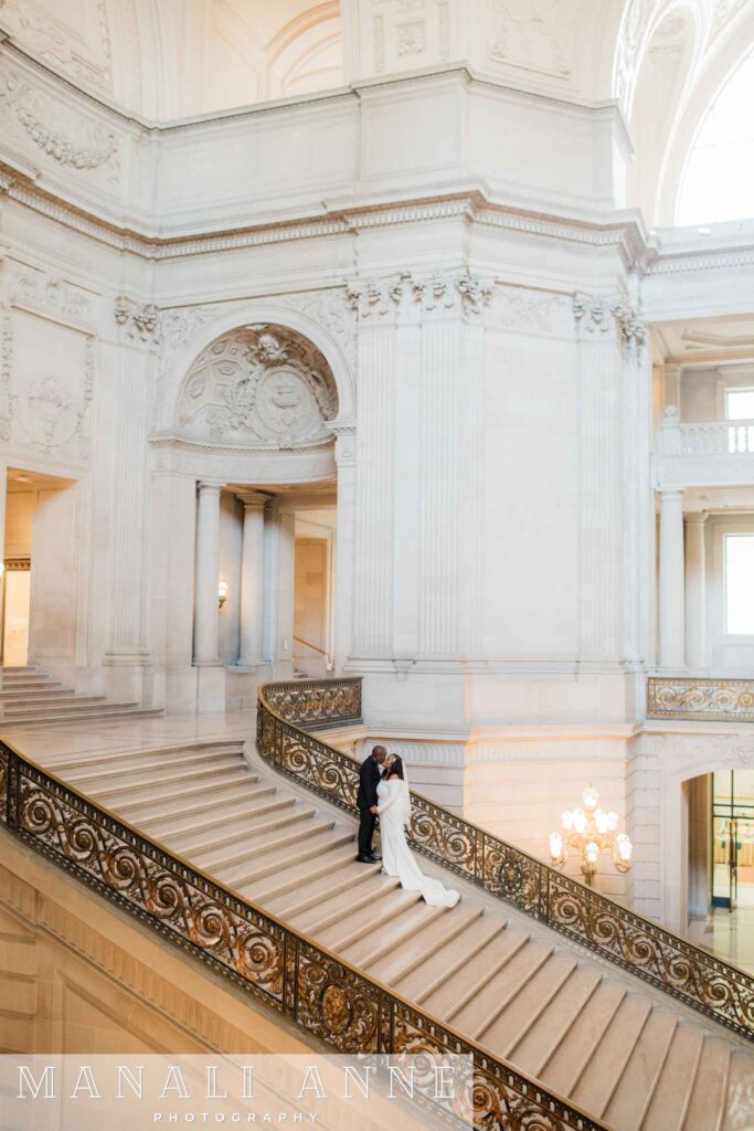 A wedding couple on the grand staircase of San Francisco city hall