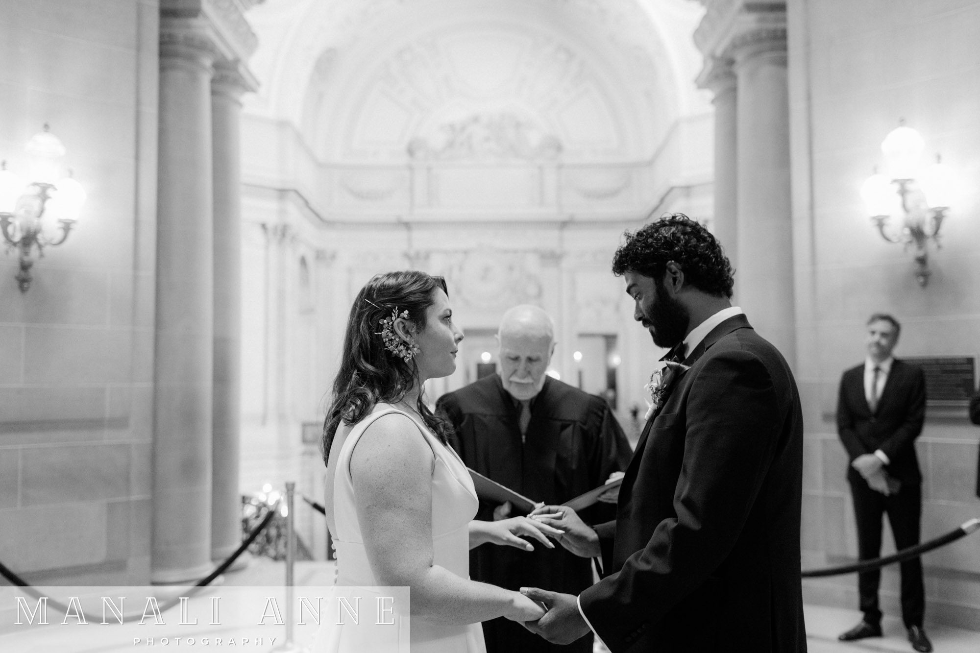 A wedding couple getting married at the rotunda during a civil ceremony at San Francisco city hall